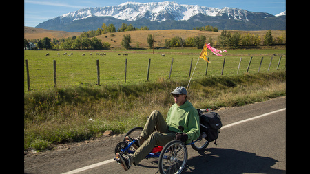 Price rides a recumbent tricycle along a rural road near Joseph, Oregon. He doesn't own a car and gets around mostly by pedaling or walking, which he says saves money and helps keep him fit. In 2001, he got a sponsorship from a tricycle manufacturer and chronicled a 4,500-mile bike journey from Ore. to Key West, Fla., in his journal.