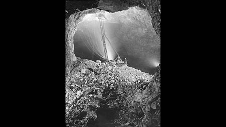 An historical image shows miners operating a 35-foot jumbo drill in a cavern below Picher. 