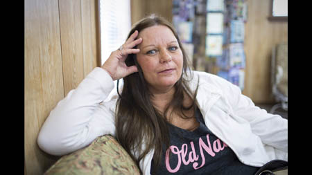 Karen Harvey, 53, waits for her medication at the Ole Miners Pharmacy. She went on disability two years ago, suffering from anxiety, respiratory problems and a thyroid condition. Harvey lived in Picher from 1960 to 2002, and as a kid she played on chat piles and swam in mill ponds. 'We'd go swimming in them and our hair would turn orange and it wouldn't wash out,' she said. At age 18 she had surgery to correct bone growth in her ears that interfered with hearing. Noting that she's also dyslexic and was recently tested with an I.Q. of 65, she said she's starting to wonder if her childhood in Picher contributed to her health problems. 'I don't know if that has something to do with it or not,' she said, 'I'm just figuring it out as I get older.'