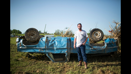Wade Lentz stands next to his wrecked 1980 Chevy Silverado in Vilonia, Ark., after a tornado wiped out his house and blew the truck 150 yards away. 